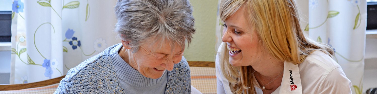 Eine jüngere und eine ältere Dame lachen gemeinsam.