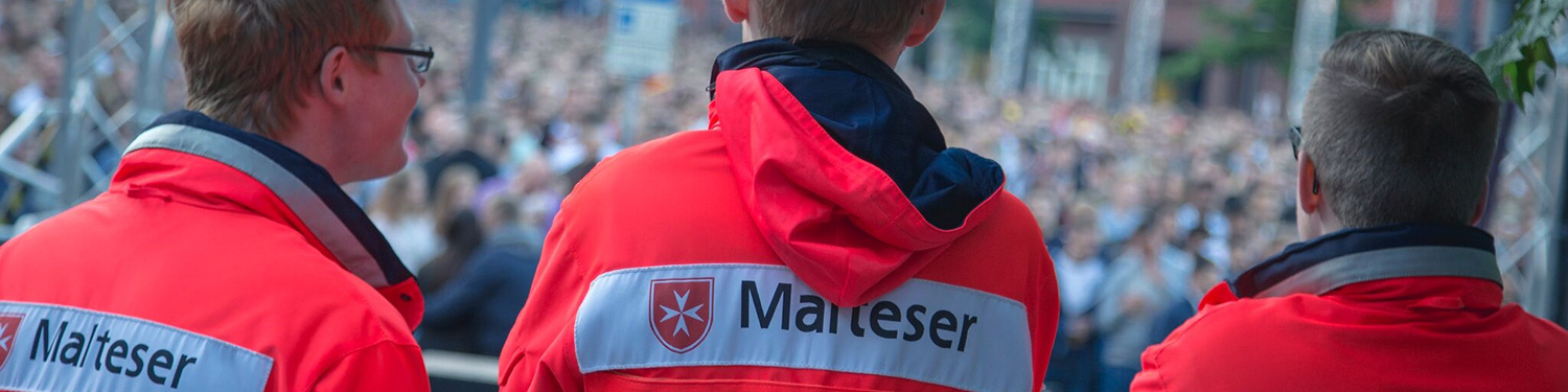 Drei Helfer der SEG schauen auf die Teilnehmer eines Public-Viewing-Events.