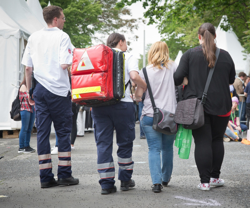 Sanitätsdienst Malteser Lohne Zwei Helfer der Malteser begleiten zwei Patienten auf dem Weg zum Patientenversorgungszelt.