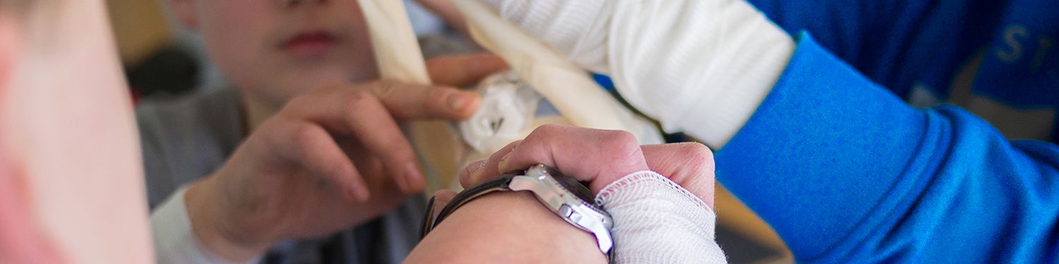 Helfer verbinden einen Arm mit Verbandsmaterial.